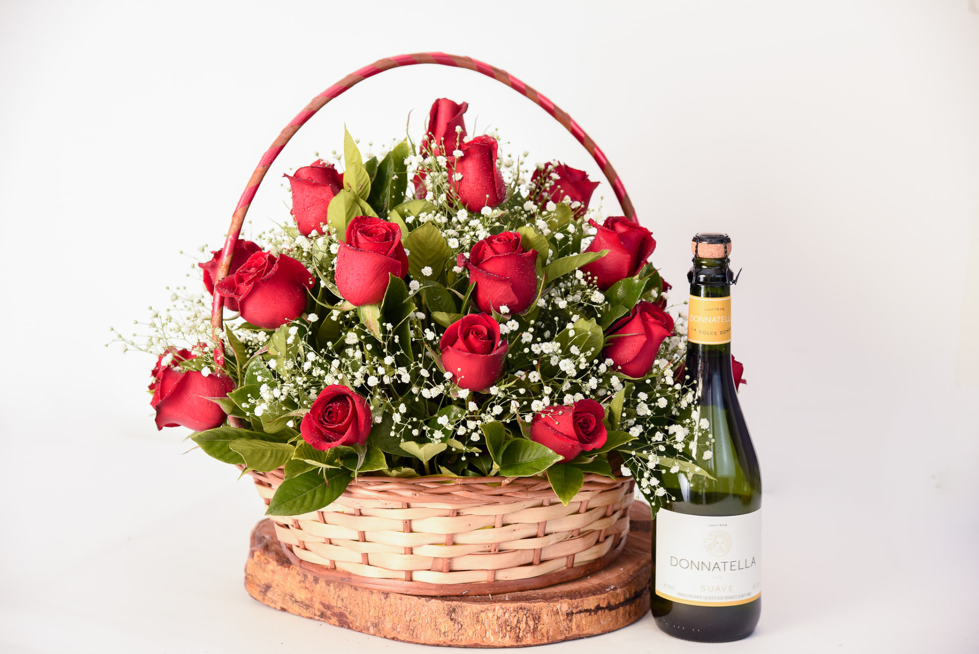 Arranjo de rosas vermelhas em cesta com espumante